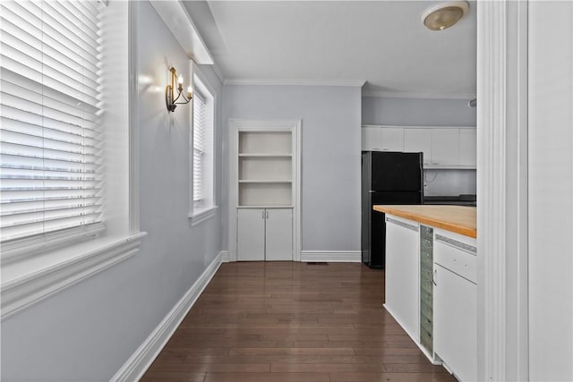 kitchen featuring dark wood finished floors, freestanding refrigerator, white cabinets, crown molding, and wooden counters