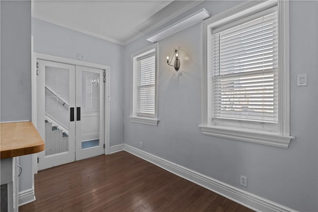 interior space with baseboards, dark wood-style flooring, and crown molding