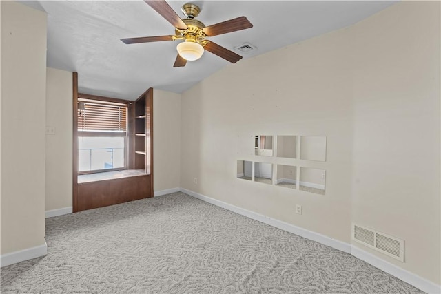 empty room featuring visible vents, baseboards, lofted ceiling, and carpet flooring