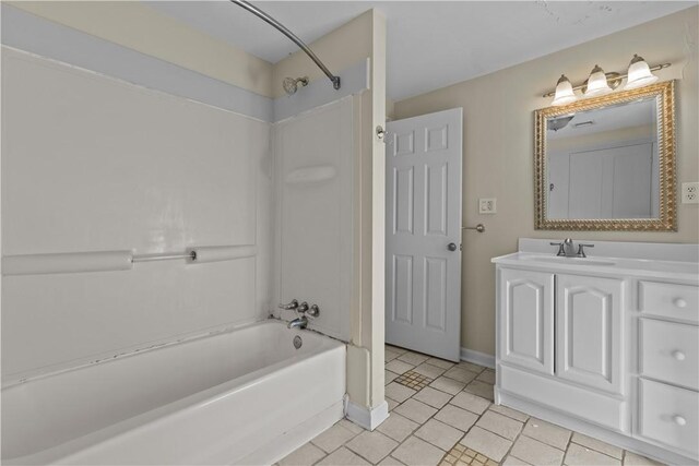 bathroom with tile patterned floors, baseboards, bathing tub / shower combination, and vanity