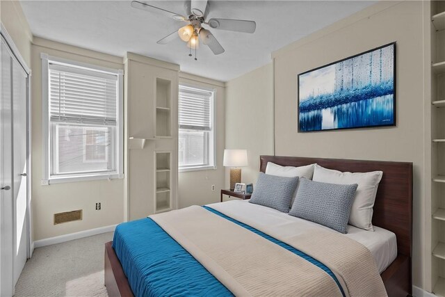 carpeted bedroom with visible vents, ceiling fan, and baseboards