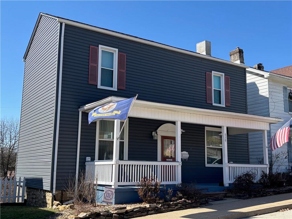 view of front of home featuring covered porch and a chimney