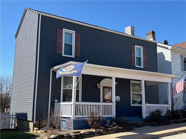 view of front of home featuring covered porch and a chimney