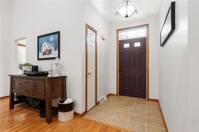 foyer with visible vents, light wood-type flooring, and baseboards