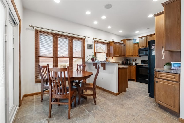 kitchen with brown cabinetry, baseboards, a peninsula, recessed lighting, and black appliances