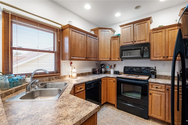 kitchen featuring brown cabinetry, recessed lighting, a sink, black appliances, and light countertops