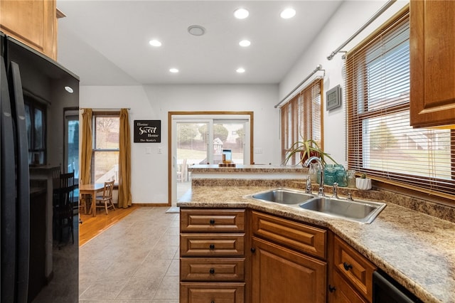 kitchen featuring a sink, freestanding refrigerator, recessed lighting, light tile patterned floors, and dishwasher