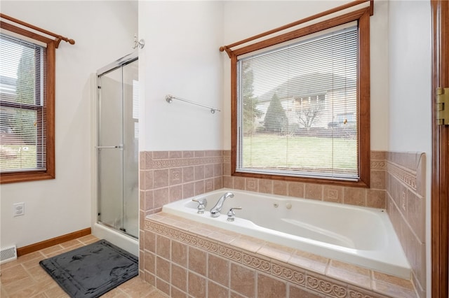 bathroom with tile patterned flooring, a shower stall, a garden tub, and a healthy amount of sunlight