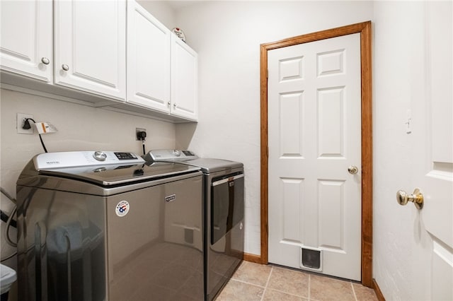 laundry room with cabinet space, light tile patterned floors, separate washer and dryer, and baseboards