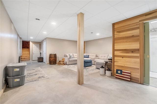 finished basement featuring stairway, recessed lighting, and a drop ceiling