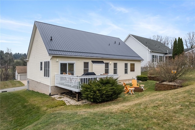 rear view of house featuring a yard, a fire pit, metal roof, and a deck