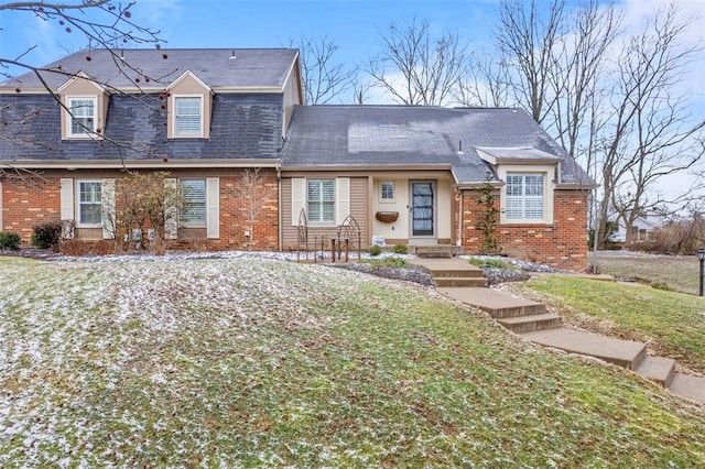 view of front of property featuring a front lawn and brick siding