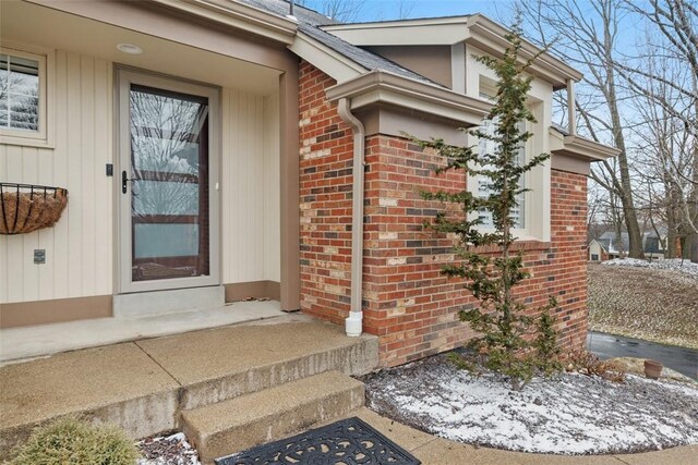 entrance to property featuring brick siding