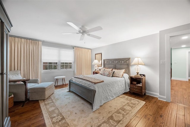 bedroom with a ceiling fan, baseboards, and hardwood / wood-style flooring