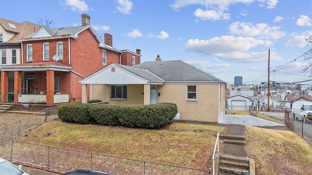 view of front of home featuring a front lawn, a porch, fence, brick siding, and a chimney