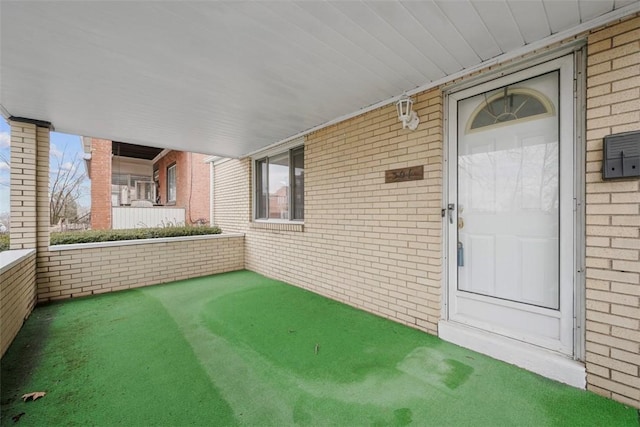 view of exterior entry featuring brick siding