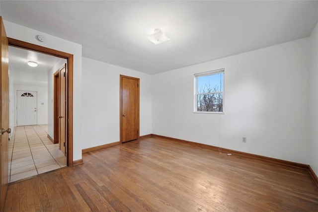 empty room featuring wood finished floors and baseboards