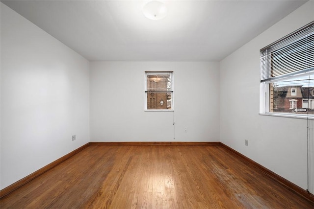 spare room with wood finished floors and baseboards