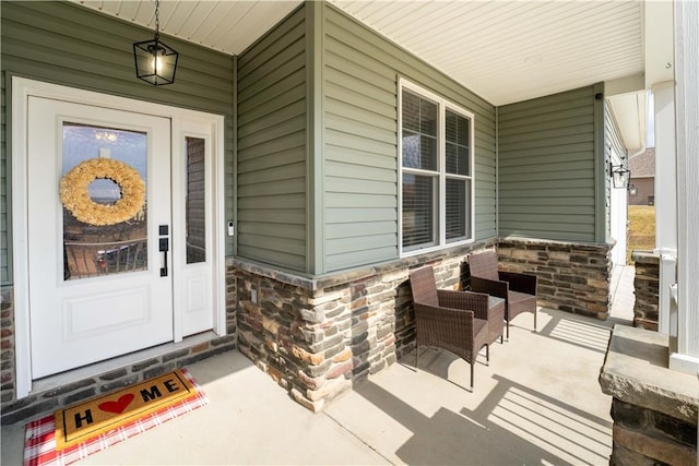 entrance to property with covered porch and stone siding