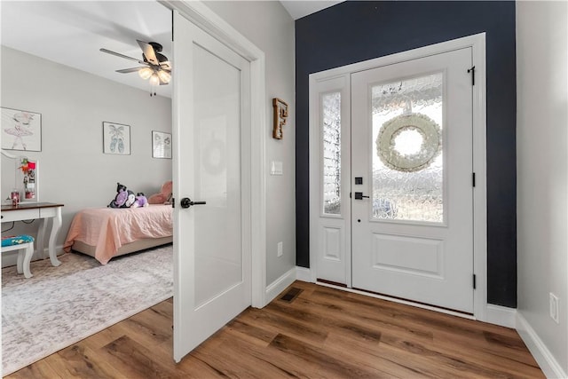 entryway with ceiling fan, visible vents, baseboards, and wood finished floors