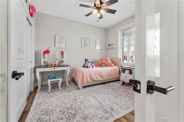 bedroom with baseboards, a ceiling fan, and wood finished floors