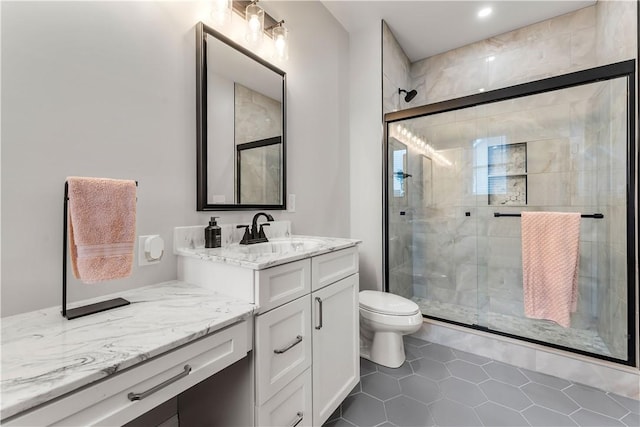 bathroom with tile patterned floors, vanity, toilet, and a shower stall