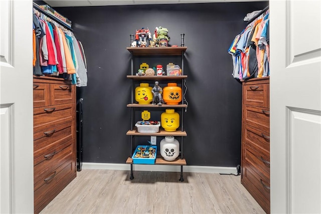 walk in closet with wood finished floors