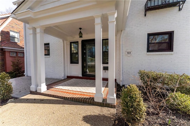 doorway to property featuring brick siding