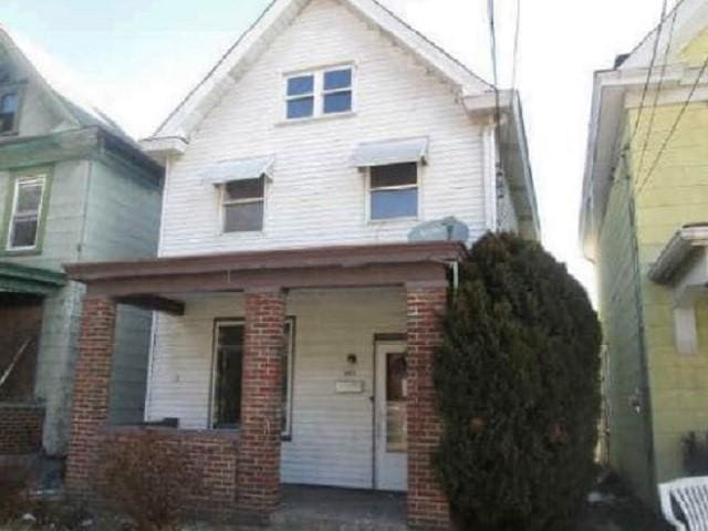 view of front facade with covered porch and brick siding