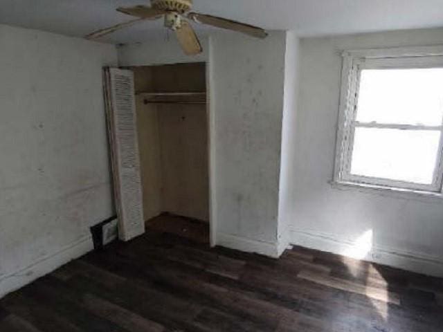 unfurnished bedroom with a ceiling fan, wood finished floors, and a closet