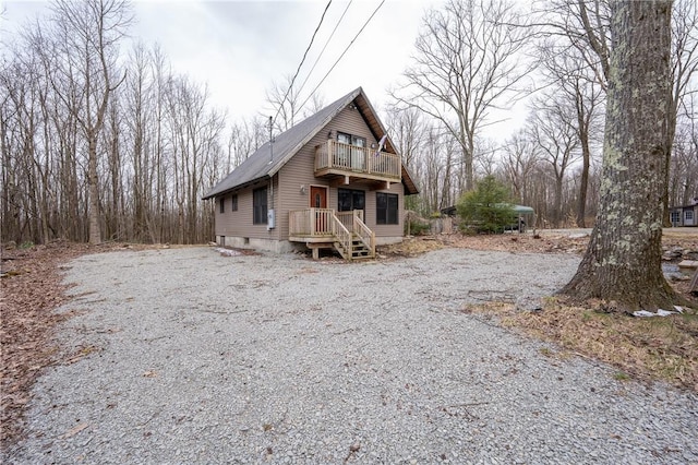 view of front of house featuring gravel driveway and a balcony