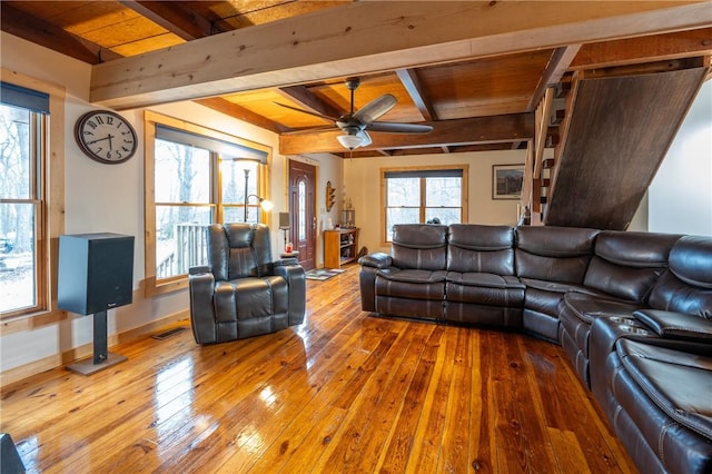 living room featuring baseboards, ceiling fan, wood-type flooring, wooden ceiling, and beamed ceiling