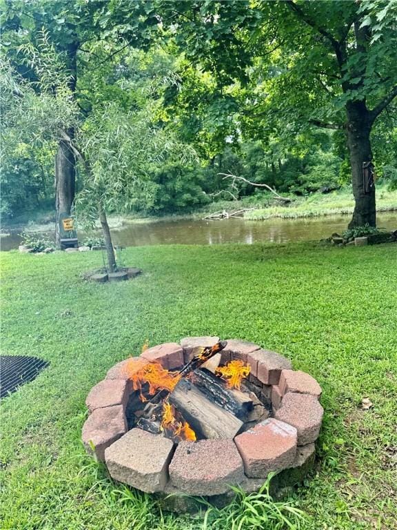 view of yard featuring a water view and an outdoor fire pit