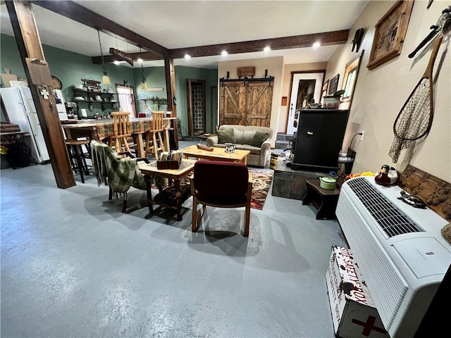 dining area featuring a barn door and beam ceiling