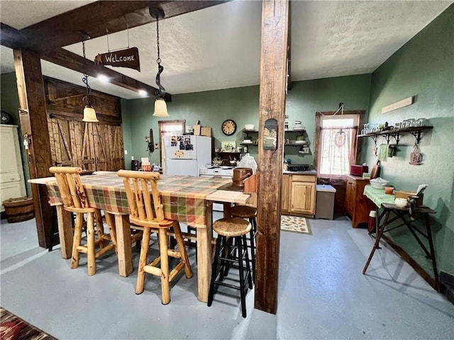 dining room featuring beamed ceiling and concrete floors