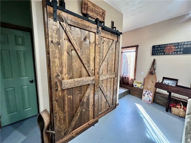 interior space featuring a barn door and concrete floors