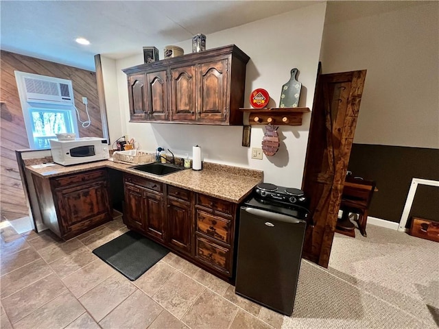 kitchen with white microwave, dark brown cabinetry, dishwasher, and a sink