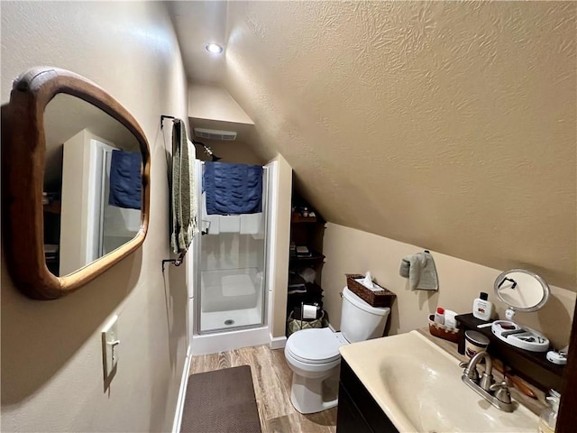 full bathroom with toilet, a stall shower, a textured ceiling, and wood finished floors