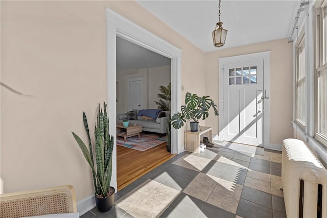 tiled foyer featuring baseboards and radiator