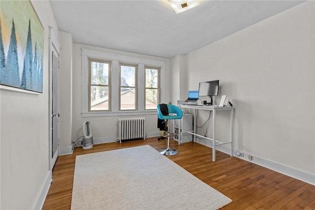 office featuring baseboards, wood finished floors, and radiator heating unit