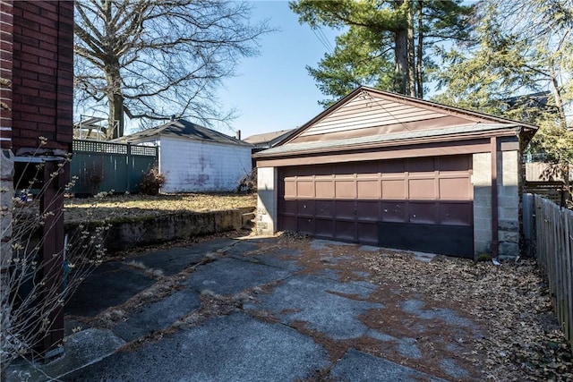 detached garage featuring fence