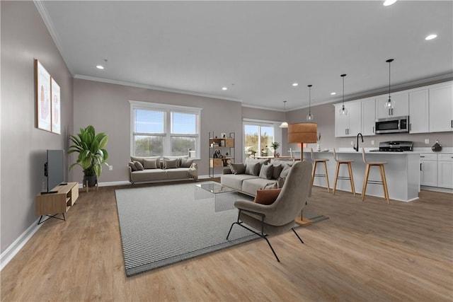 living room featuring light wood-style flooring, recessed lighting, baseboards, and ornamental molding