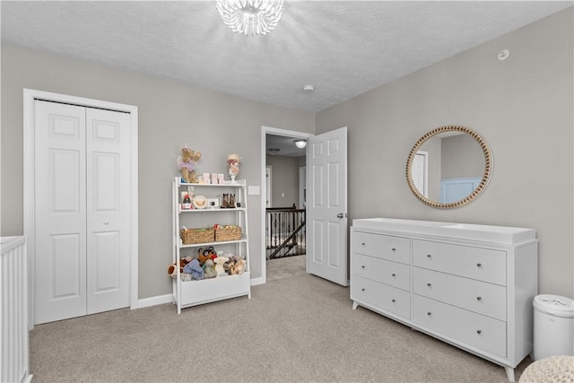 bedroom featuring a closet, carpet floors, a textured ceiling, and baseboards