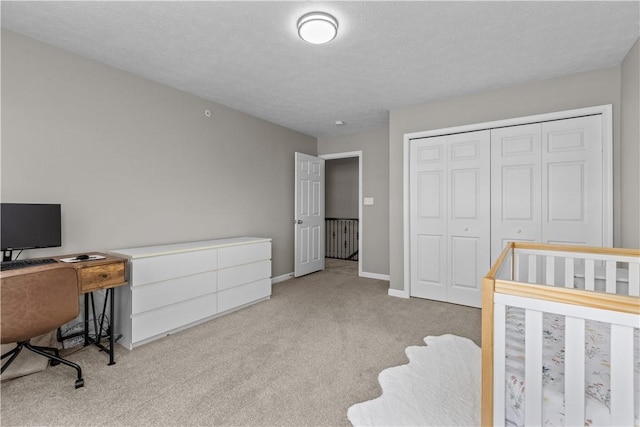 bedroom with a closet, baseboards, carpet, and a textured ceiling