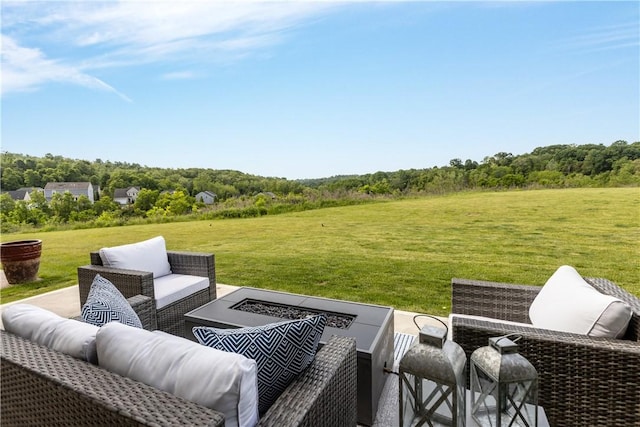 view of patio / terrace with a forest view and an outdoor living space with a fire pit