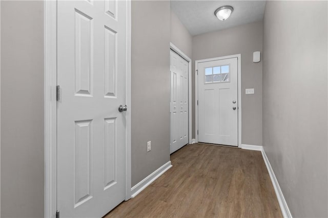 entryway with wood finished floors and baseboards