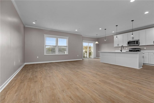 kitchen featuring stainless steel microwave, light wood-type flooring, open floor plan, and range