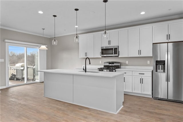 kitchen featuring a center island with sink, light wood-style flooring, a sink, appliances with stainless steel finishes, and crown molding