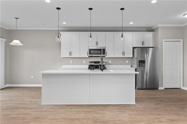 kitchen featuring an island with sink, ornamental molding, white cabinetry, appliances with stainless steel finishes, and light countertops