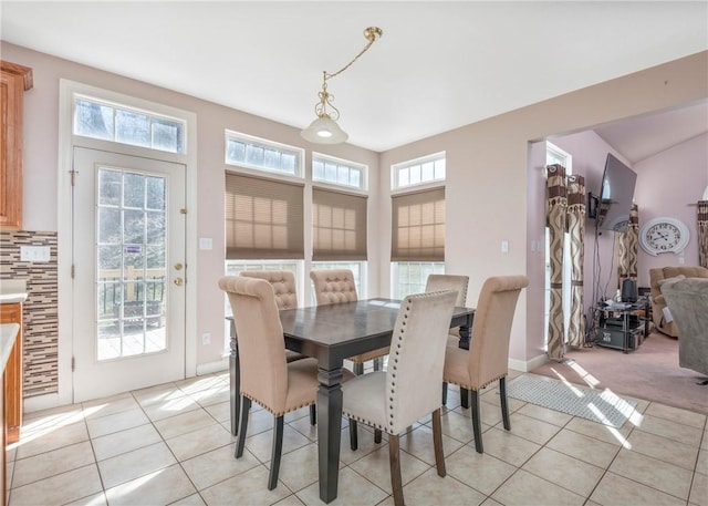 dining room featuring light tile patterned floors, light carpet, and a healthy amount of sunlight